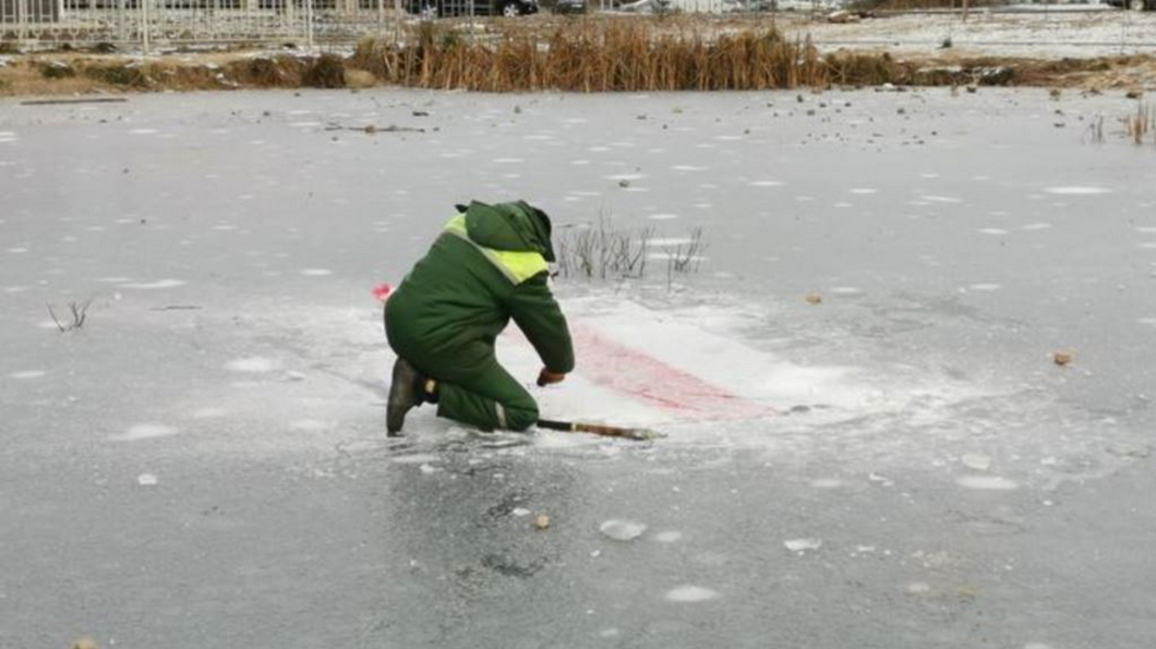 Белорусские дворники по утрам выдалбливают флаги из-подо льда 