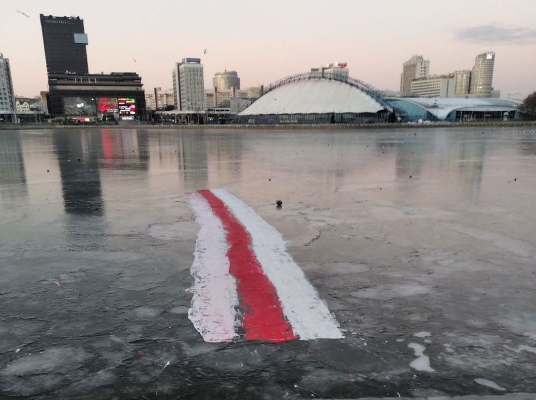 Белорусские дворники по утрам выдалбливают флаги из-подо льда 